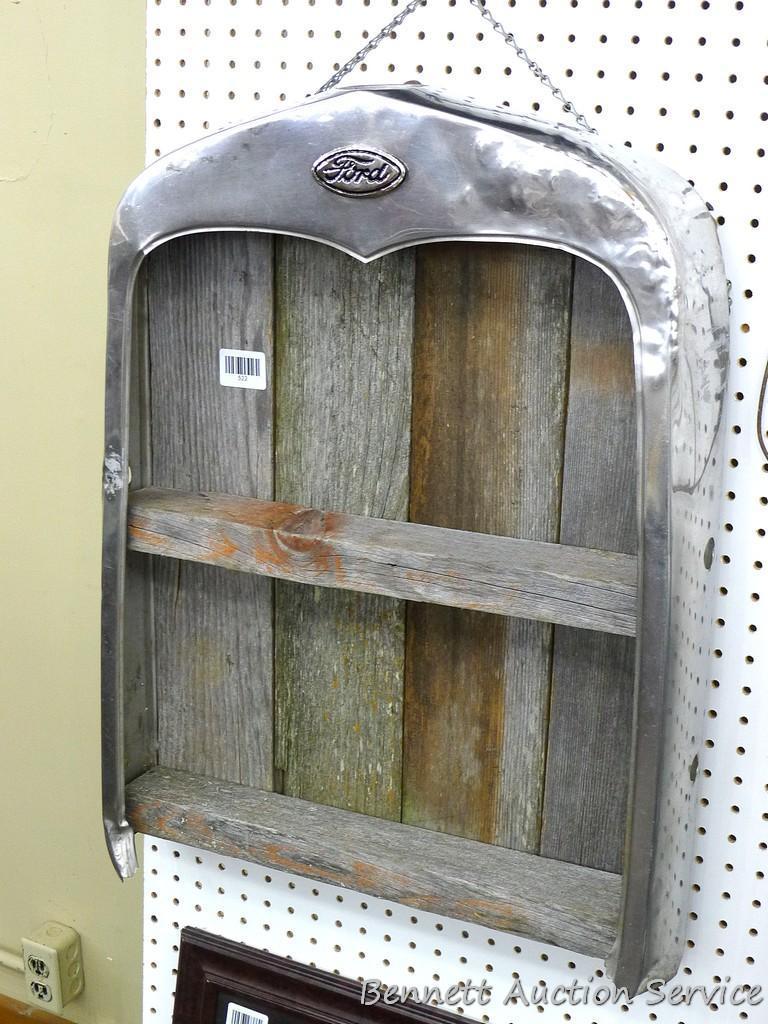 Model A radiator shell has been converted into a hanging barn board shelf. Measures approx 20" x