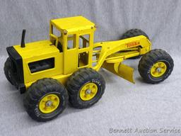 Tonka metal toy road grader is 18" x 7" x 7" tall. Wheels and blade rotate.