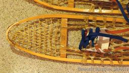 Pair of Safesport Northwoods Brand snowshoes. Both shoes have breaks in the frame. Both shoes