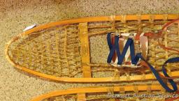 Pair of Safesport Northwoods Brand snowshoes. Both shoes have breaks in the frame. Both shoes