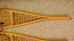 Pair of Safesport Northwoods Brand snowshoes. Both shoes have breaks in the frame. Both shoes