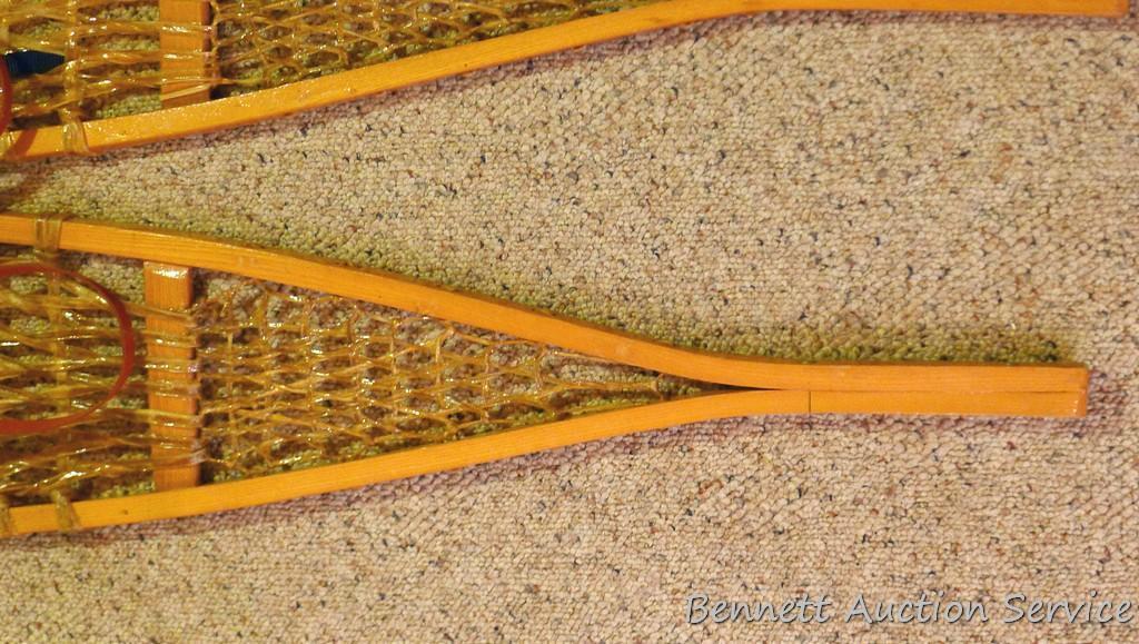 Pair of Safesport Northwoods Brand snowshoes. Both shoes have breaks in the frame. Both shoes