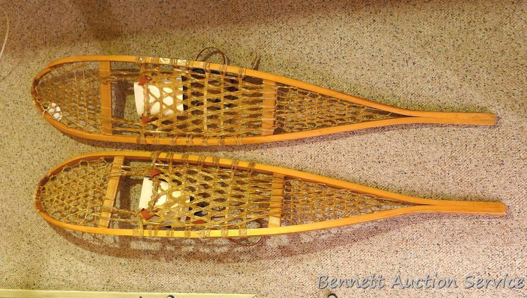 Pair of Safesport Northwoods Brand snowshoes. Both shoes have breaks in the frame. Both shoes