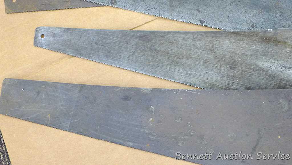 Four hand saws and square. Saws have some rust on blades and chips on handles. Longest saw measures
