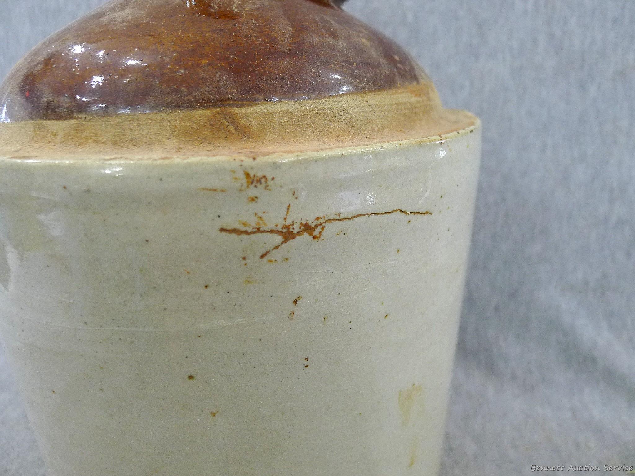 Stoneware jug stands nearly 11" overall.