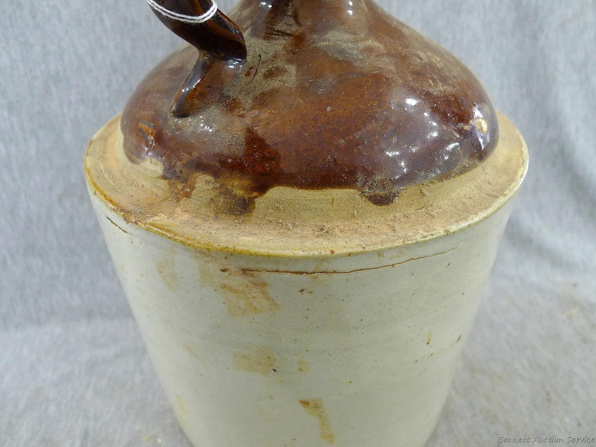 Stoneware jug stands nearly 11" overall.