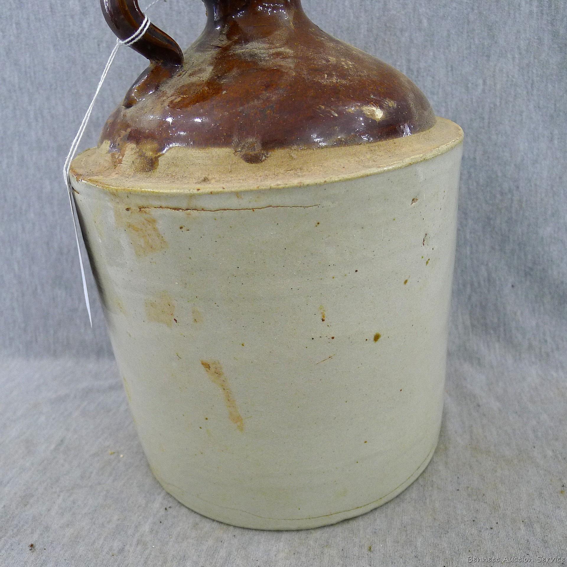 Stoneware jug stands nearly 11" overall.