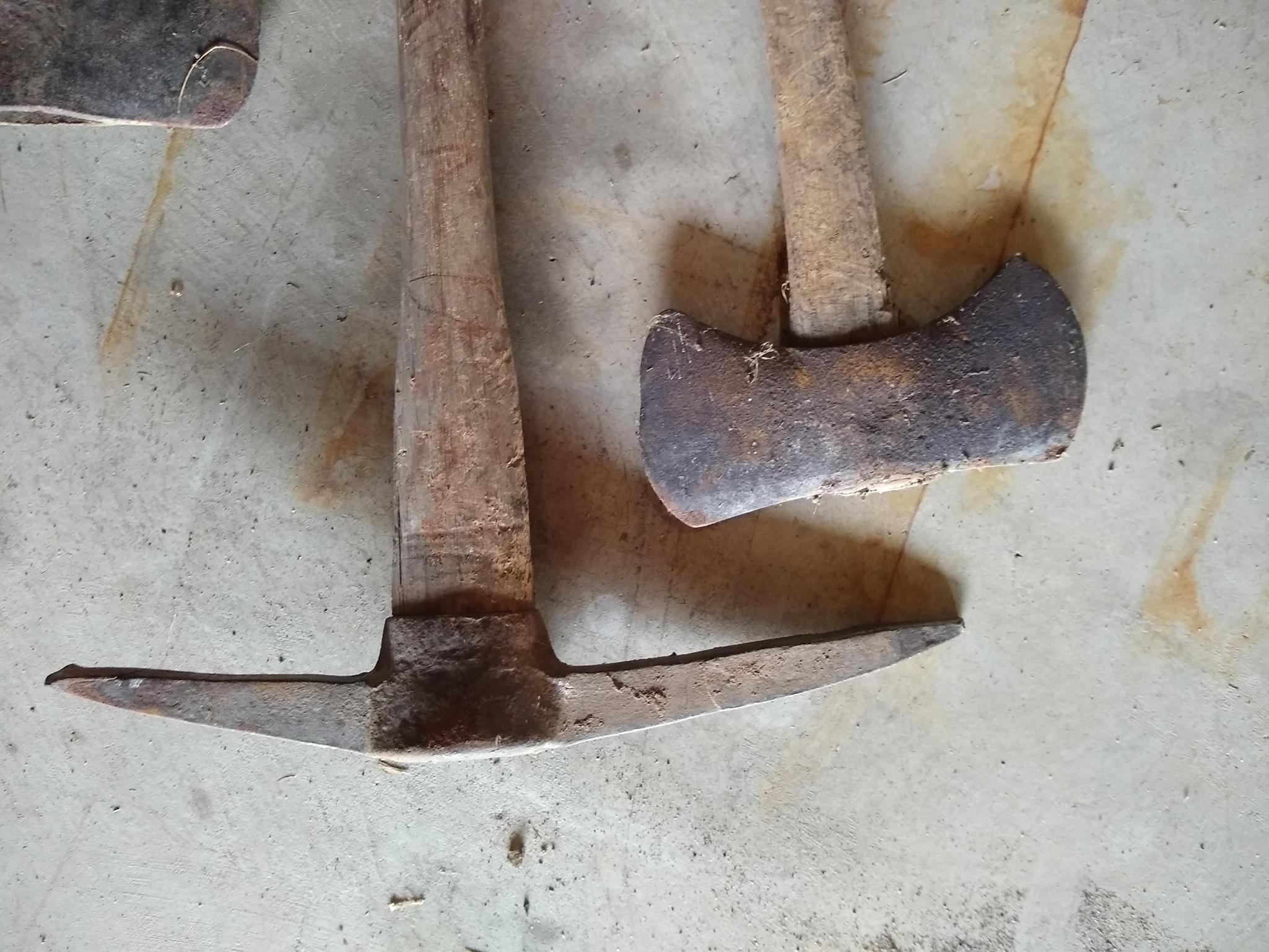 Two double bit axes and a double sided pick axe. Larger double bit axe has a 36" long handle and is