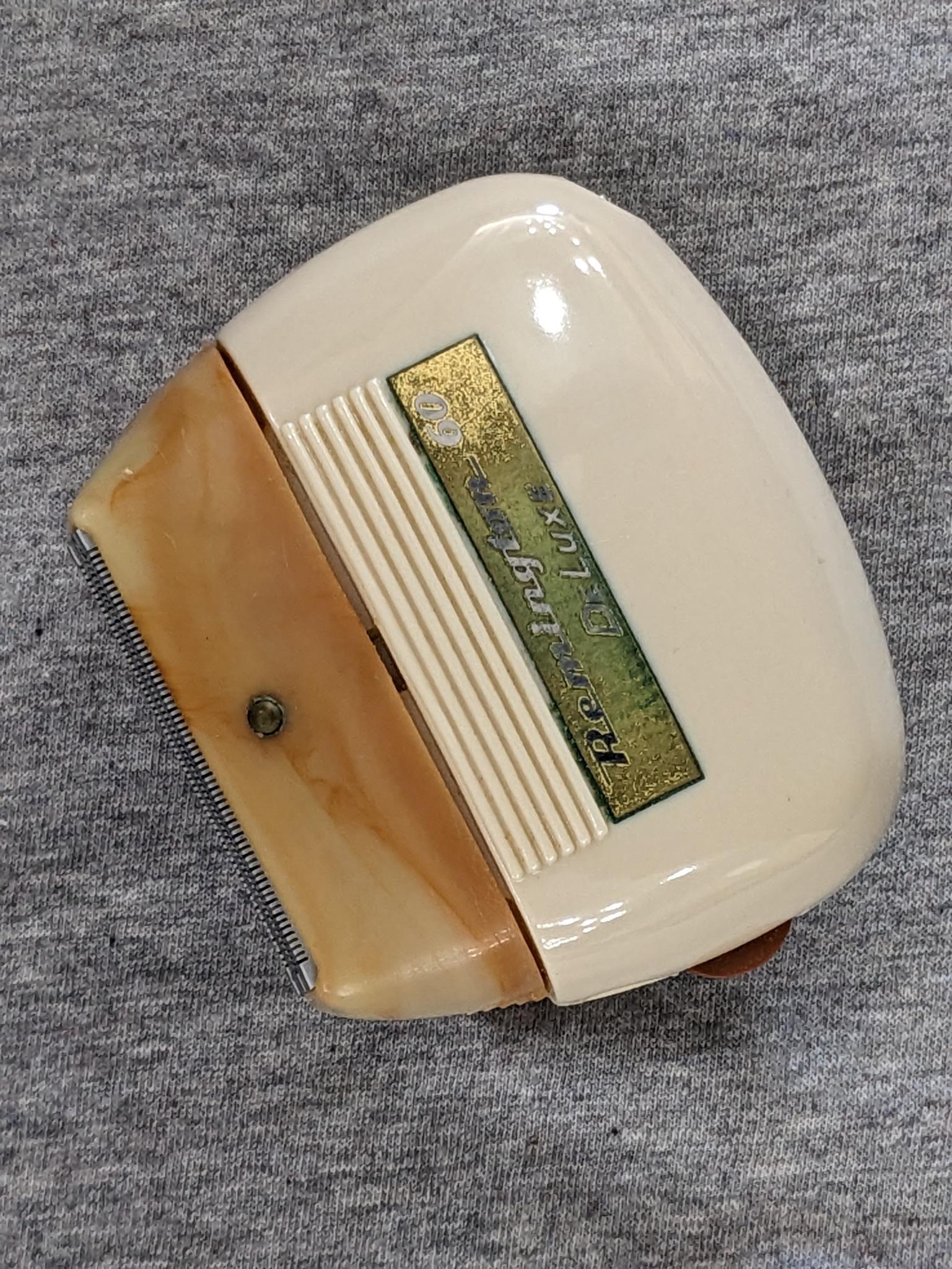 Remington 60 Deluxe electric shaver in original case; shaver measures 3" x 2-3/4".