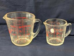 Set of 2 Fire King glass measuring cups include a 1 cup and 2 cup; larger measures 5" tall.