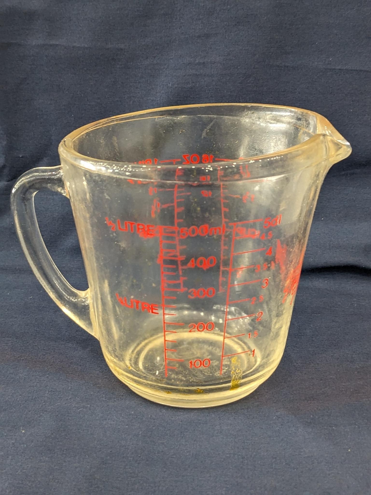 Set of 2 Fire King glass measuring cups include a 1 cup and 2 cup; larger measures 5" tall.