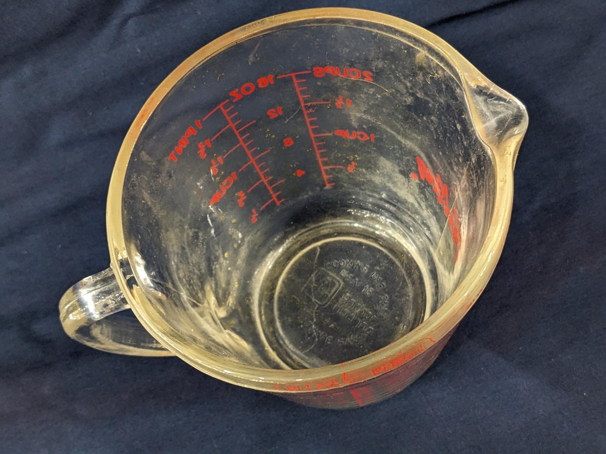 Set of 2 Fire King glass measuring cups include a 1 cup and 2 cup; larger measures 5" tall.