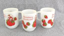 Three old Strawberry Shortcake mugs were made by Anchor Hocking. A couple chips noted on one rim and