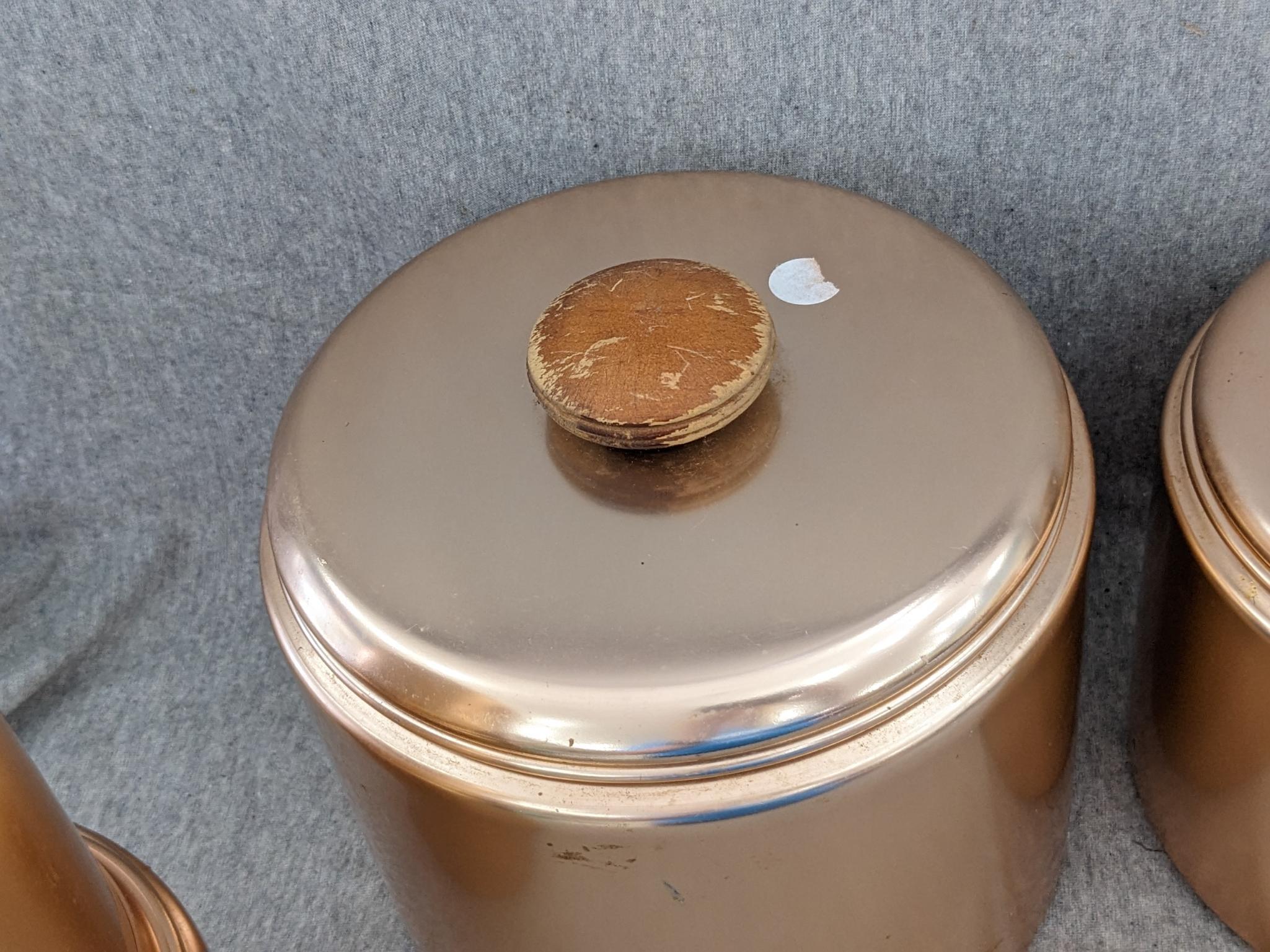 Set of Mirro rose gold canisters. Up to 4 qts. Knobs a little worn but canisters in good condition.