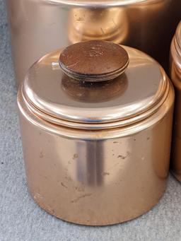 Set of Mirro rose gold canisters. Up to 4 qts. Knobs a little worn but canisters in good condition.