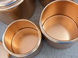 Set of Mirro rose gold canisters. Up to 4 qts. Knobs a little worn but canisters in good condition.