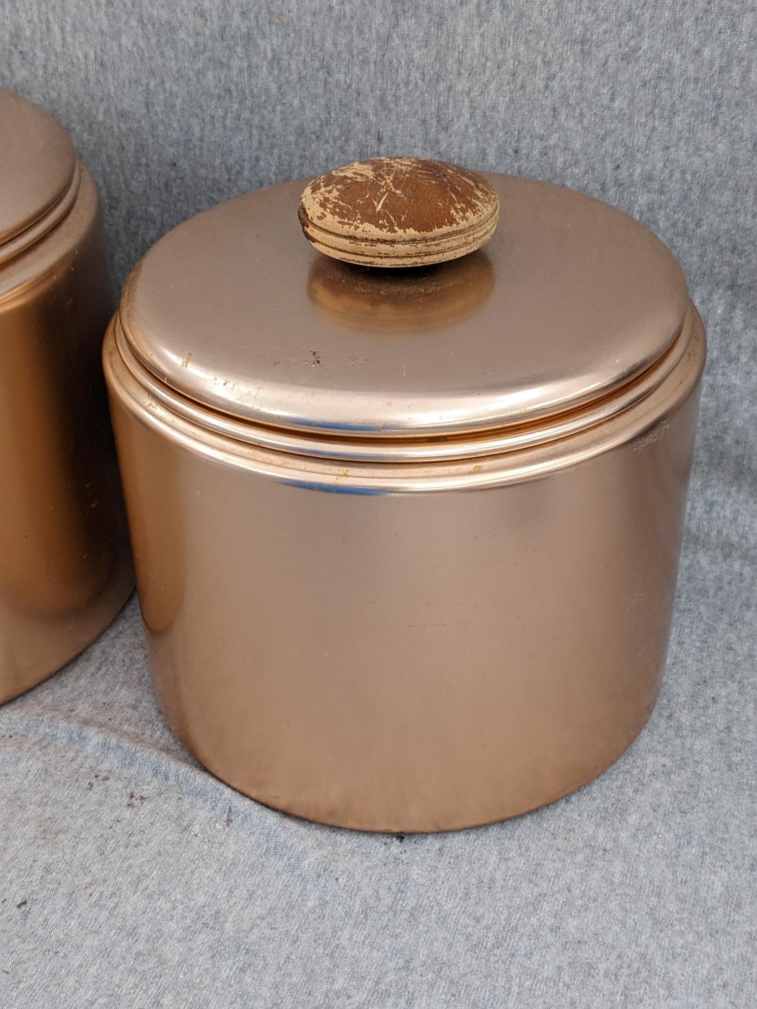 Set of Mirro rose gold canisters. Up to 4 qts. Knobs a little worn but canisters in good condition.
