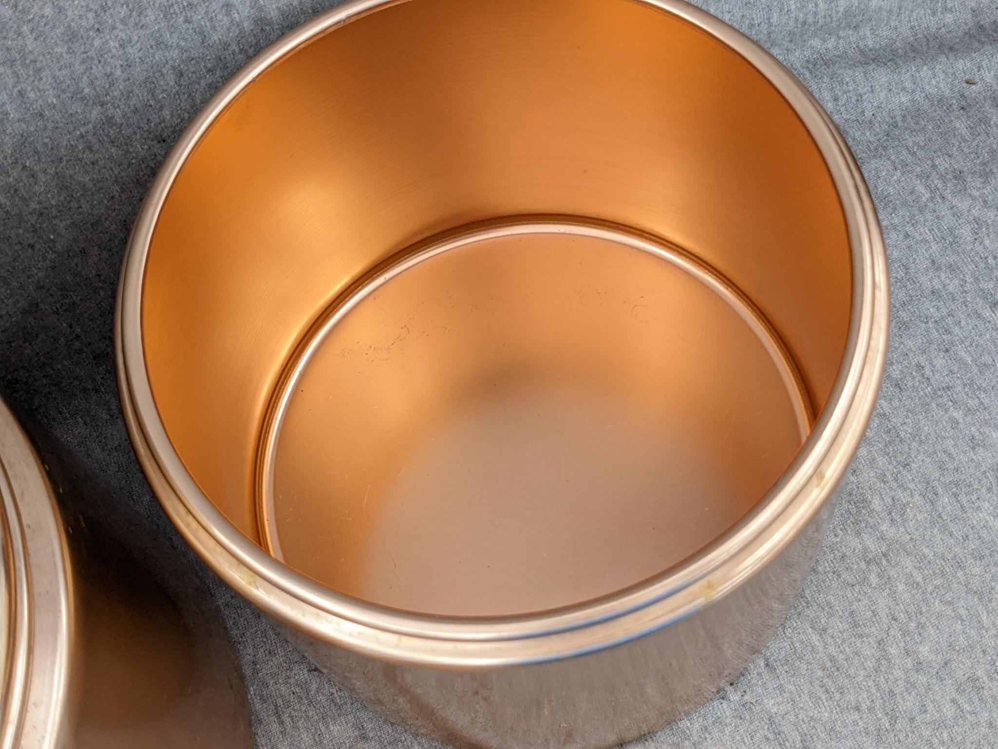 Set of Mirro rose gold canisters. Up to 4 qts. Knobs a little worn but canisters in good condition.
