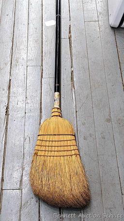 Sturdy corn broom has a wooden handle.