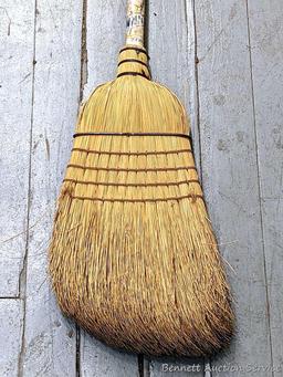 Sturdy corn broom has a wooden handle.
