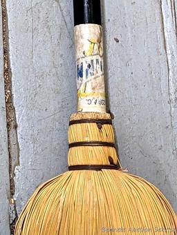 Sturdy corn broom has a wooden handle.