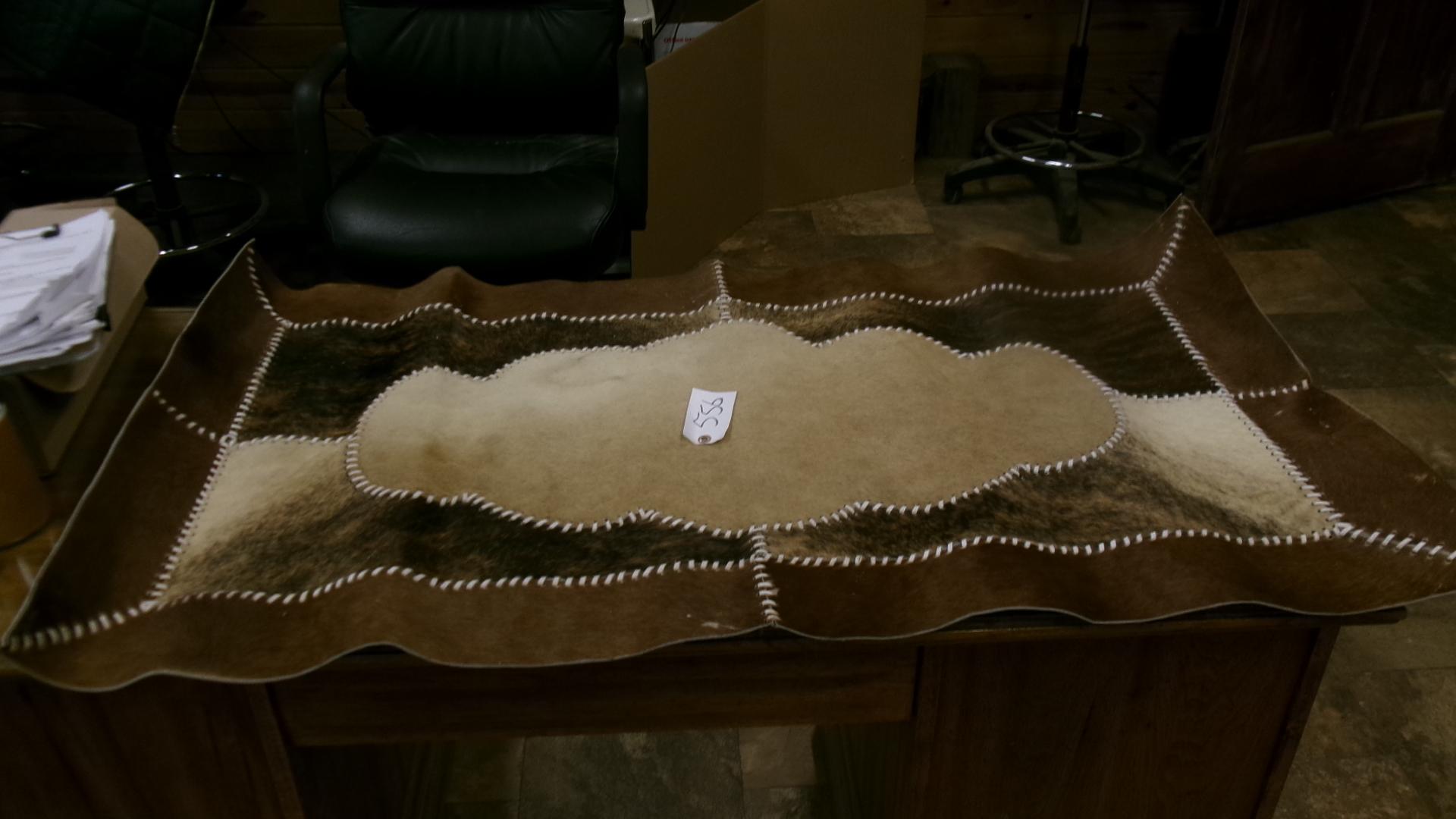 26" X 49" COWHIDE RUG, BEAR SKULL, 11 BEAR CLAWS, & A SHARK TOOTH