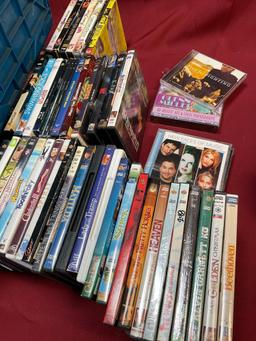 Assorted DVDs and CDs. Over 80 pieces includes storage tub