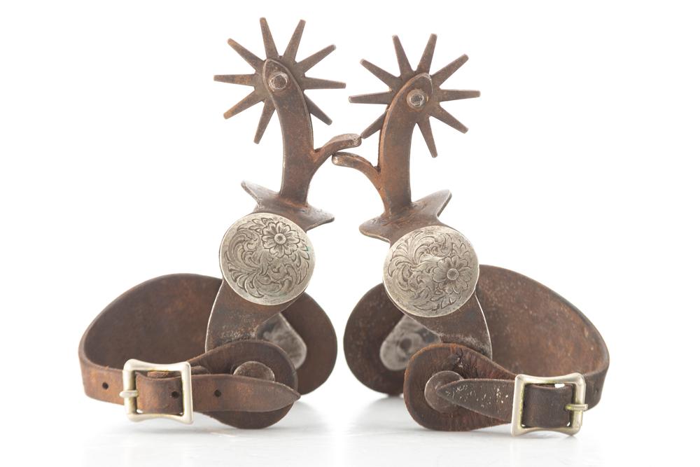 Pair of single mounted Iron Spurs with engraved silver conchos on heel bands. Believed to be shop-ma