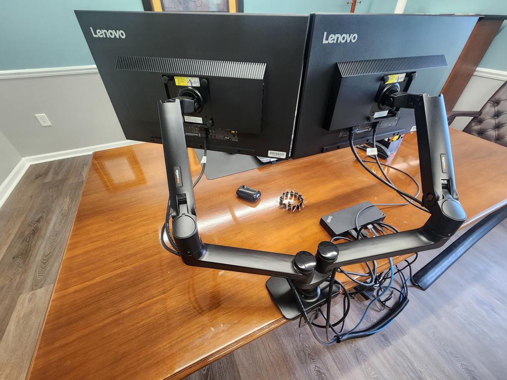 Executive office furniture with desk, chairs, and Lenovo dual monitors and keyboard
