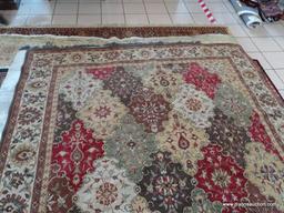MACHINE MADE ORIENTAL STYLE RUG IN BROWN, IVORY, AND RED. MEASURES APPROXIMATELY 7 FT 8 IN X 10 FT 1