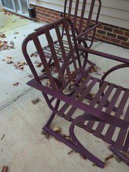 (BACK) DARK PURPLE PATIO SET WITH ROUND GLASS TOP TABLE AND 4 ARM CHAIRS. TABLE MEASURES APPROX 48"