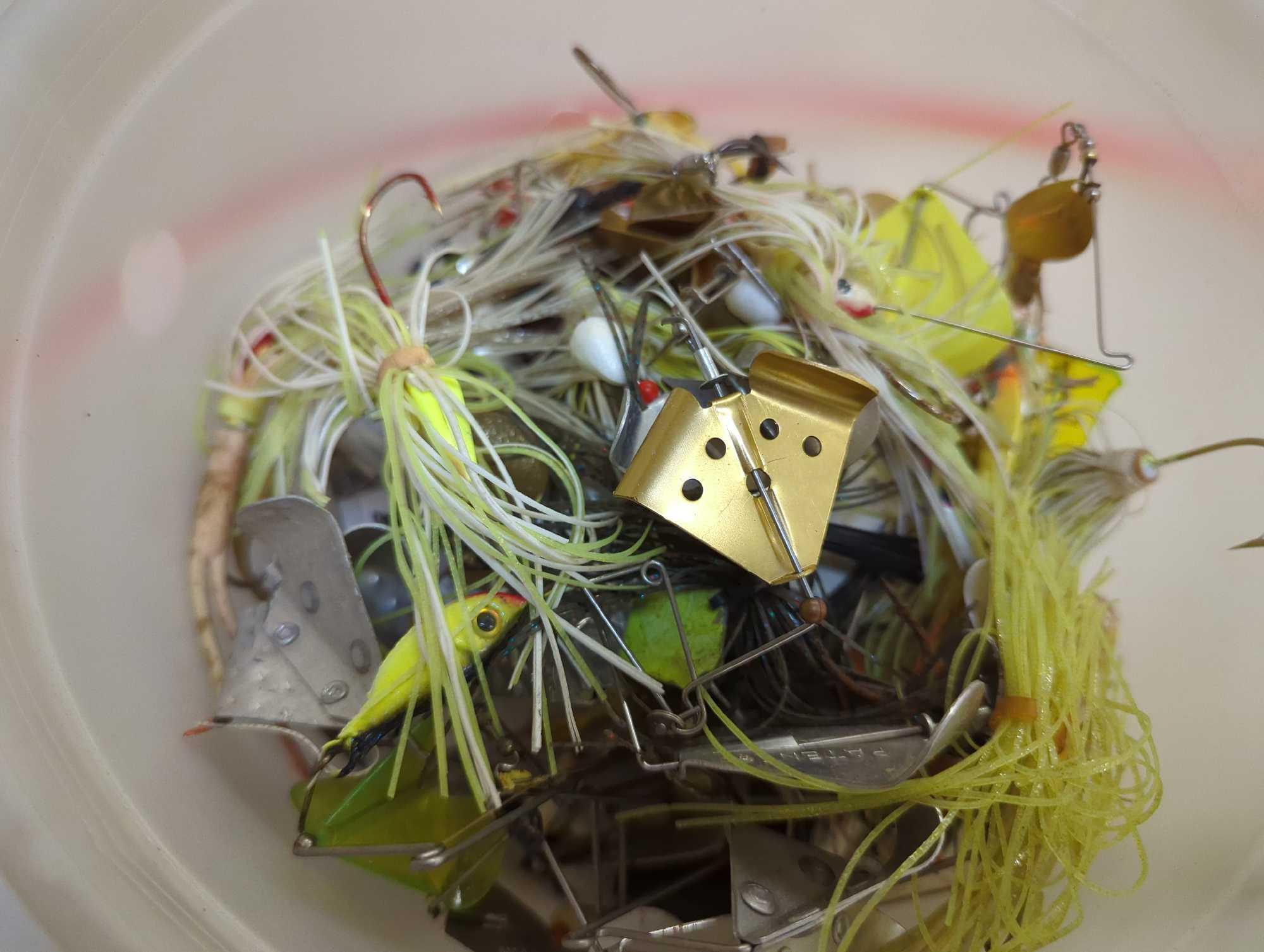 Bucket and 2 mini tackle boxes containing fishing lures of similar style and bullet weights.