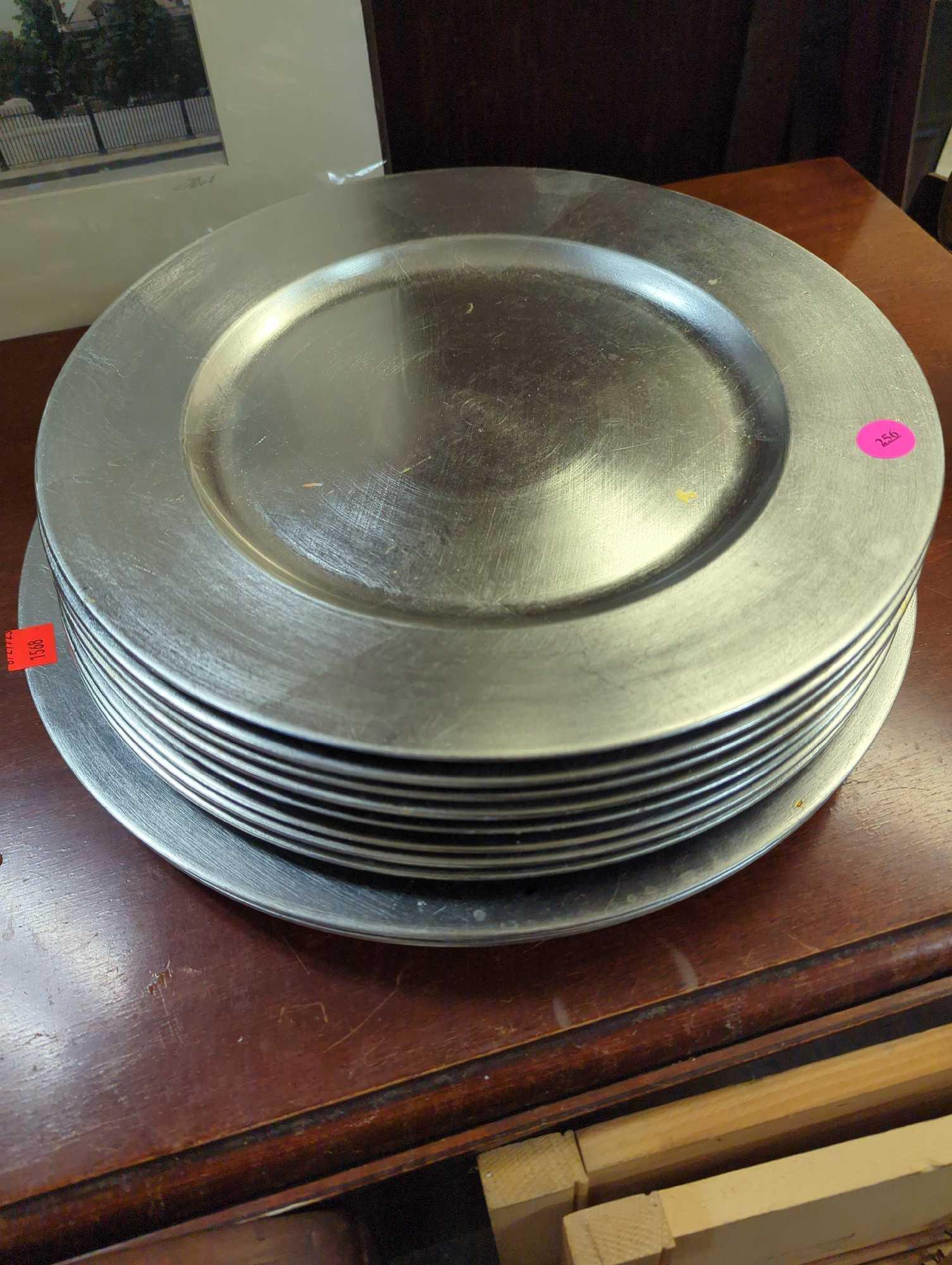 Set of 11 silver plastic charger plates. Comes as is shown in photos. Appears to be used.