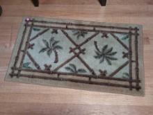 (BR2) DECORATIVE PALM TREE FLOOR MAT. IT MEASURES 33-1/4"W X 20"D.