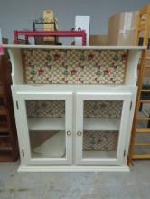 White Wooden Cabinet With Glass Doors and Apple Patterned Backing