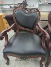 Carved Wood Armchair with Black Upholstery and Decorative Accents
