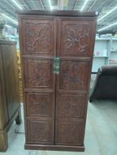 Ornately Carved Wooden Cabinet With Double Doors and Brass Hardware