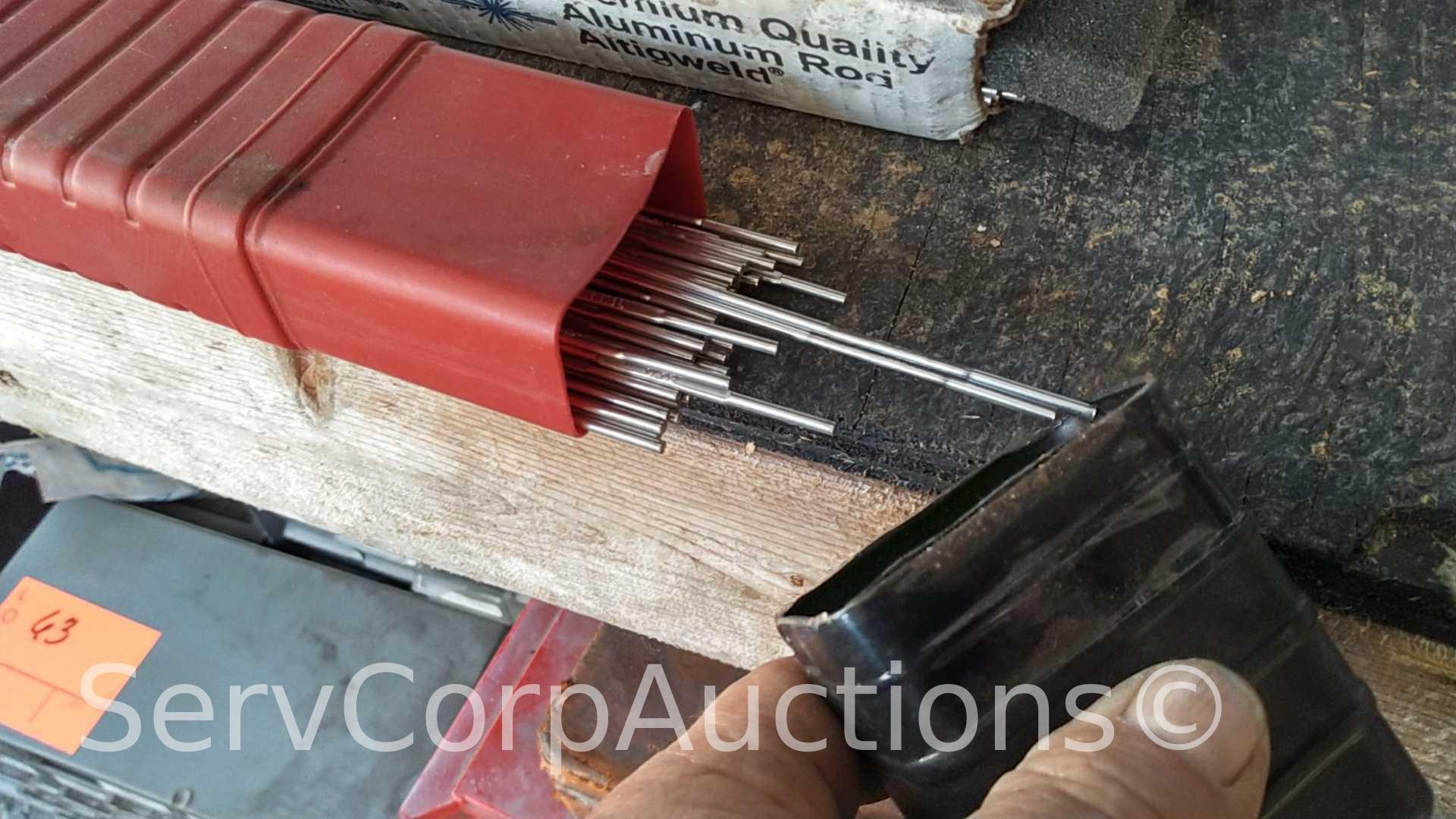 Lot on Shelf of Various Tigweld Rods & Wire Feeder Rolls