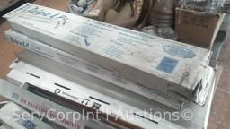 Lot Under Pallet Rack of Various Fluorescent Bulbs, Lighting Shades, Blacktex Rails, Ceiling Mount
