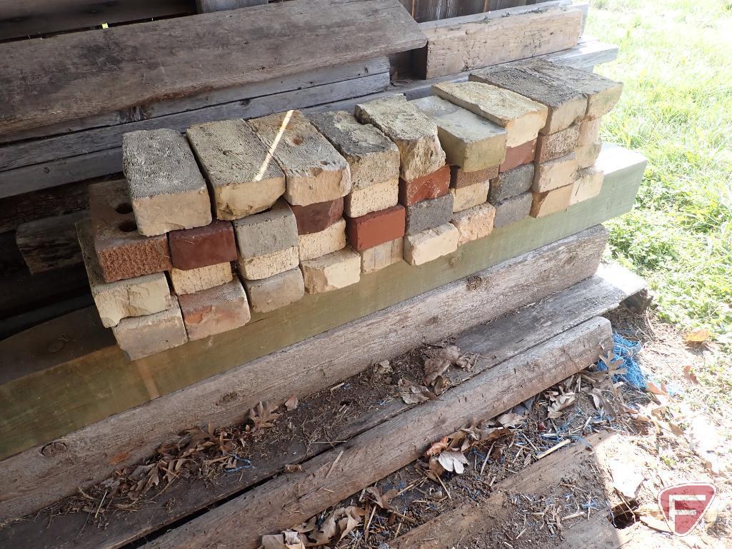 Contents of shed; lumber, bricks, wood crates, wood shelf, wood fence panels, plastic pallets