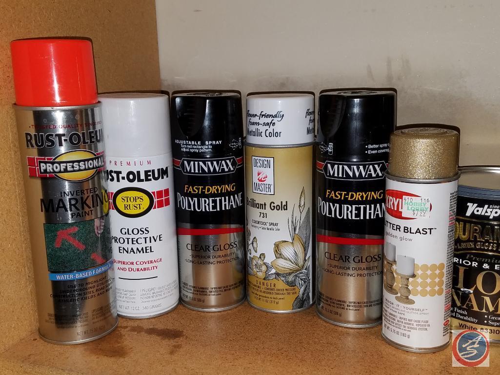Assorted painting supplies, open cans of paint and spray paint