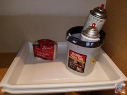 Assorted painting supplies, open cans of paint and spray paint