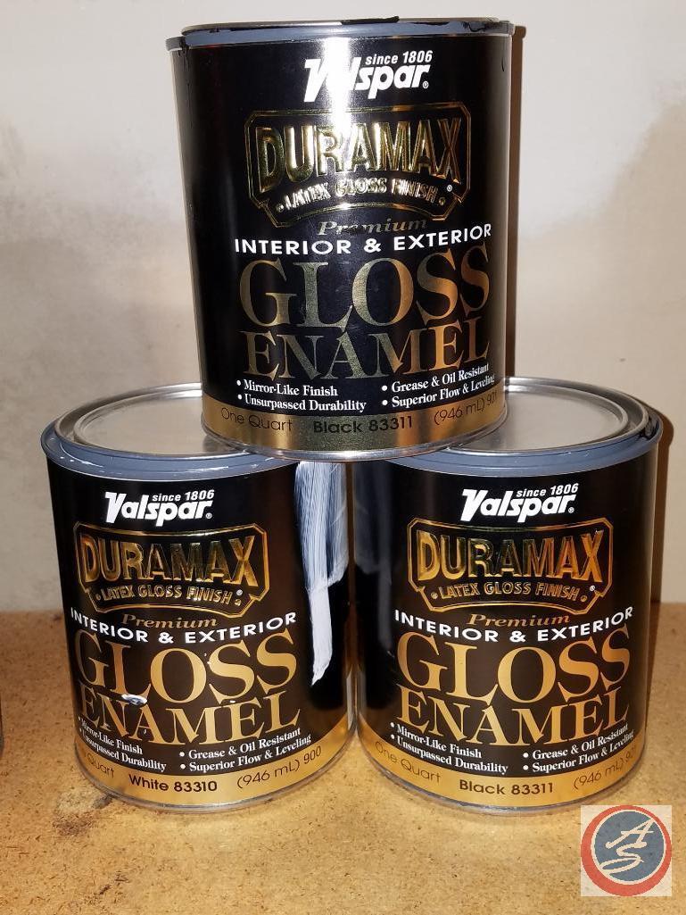 Assorted painting supplies, open cans of paint and spray paint