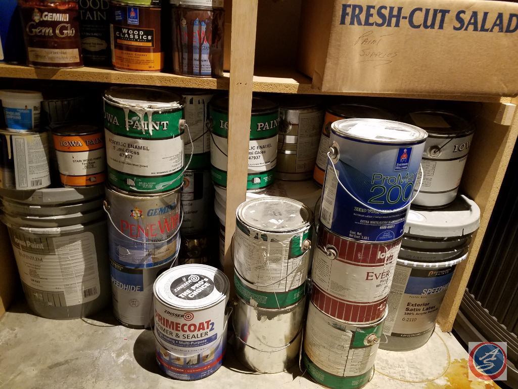 Assorted painting supplies, open cans of paint and spray paint