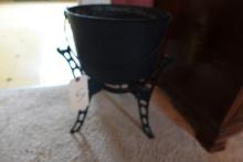 CAST IRON STAND WITH CAST IRON POT APPROX 11 INCH X 9 INCH THE POT IS FOOTE