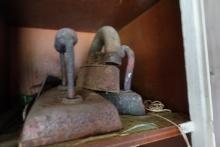 CONTENTS OF WOODEN CABINET ANTIQUE IRONS DOOR KNOBS LUBRICANTS AND MORE