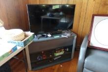 VIZIO 38 INCH FLAT SCREEN TV AND ENTERTAINMENT STAND AND CONTENTS