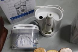 Shoe polishing brushes, scissors, vintage electric razors, and a Waterpik flosser, new in box