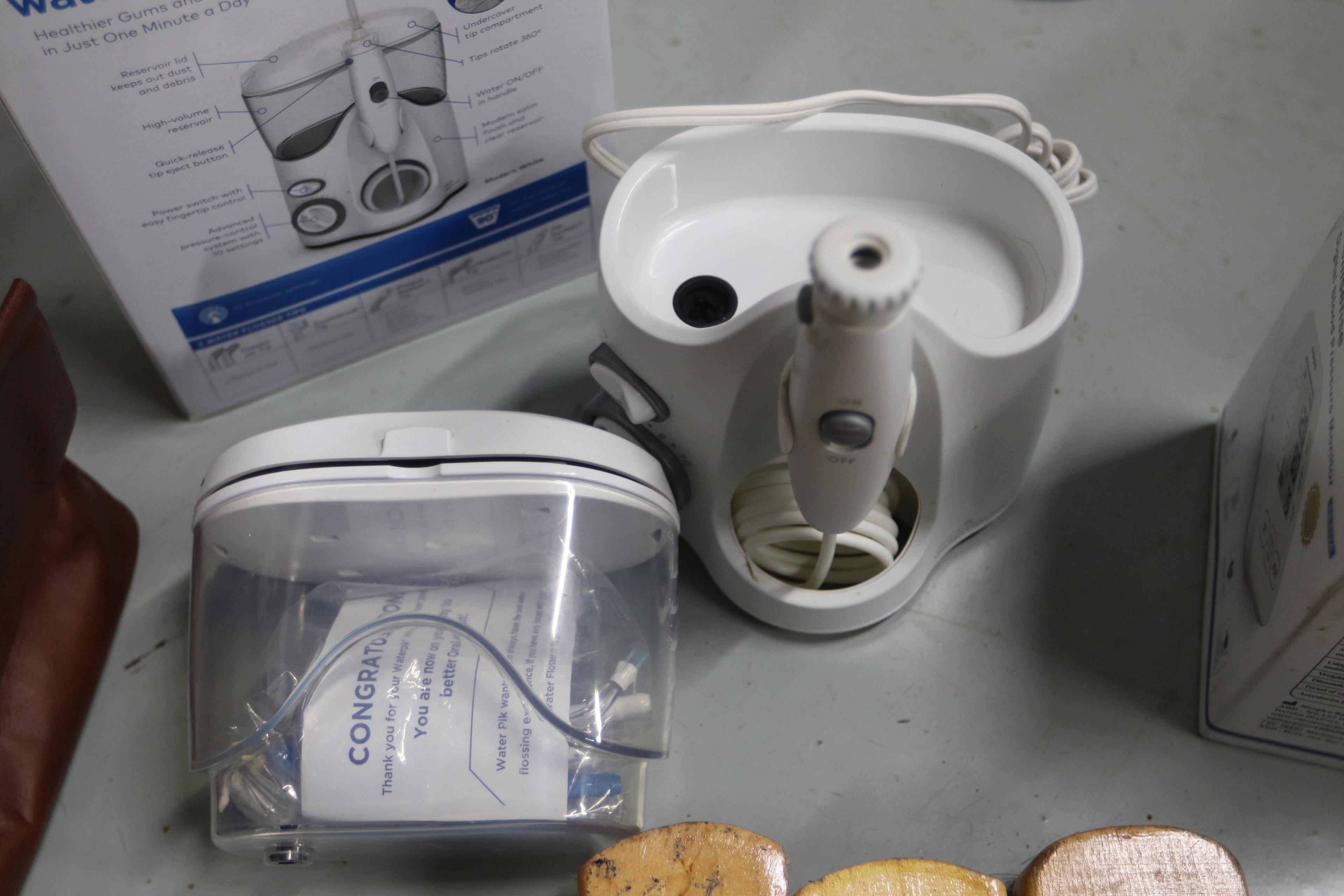 Shoe polishing brushes, scissors, vintage electric razors, and a Waterpik flosser, new in box