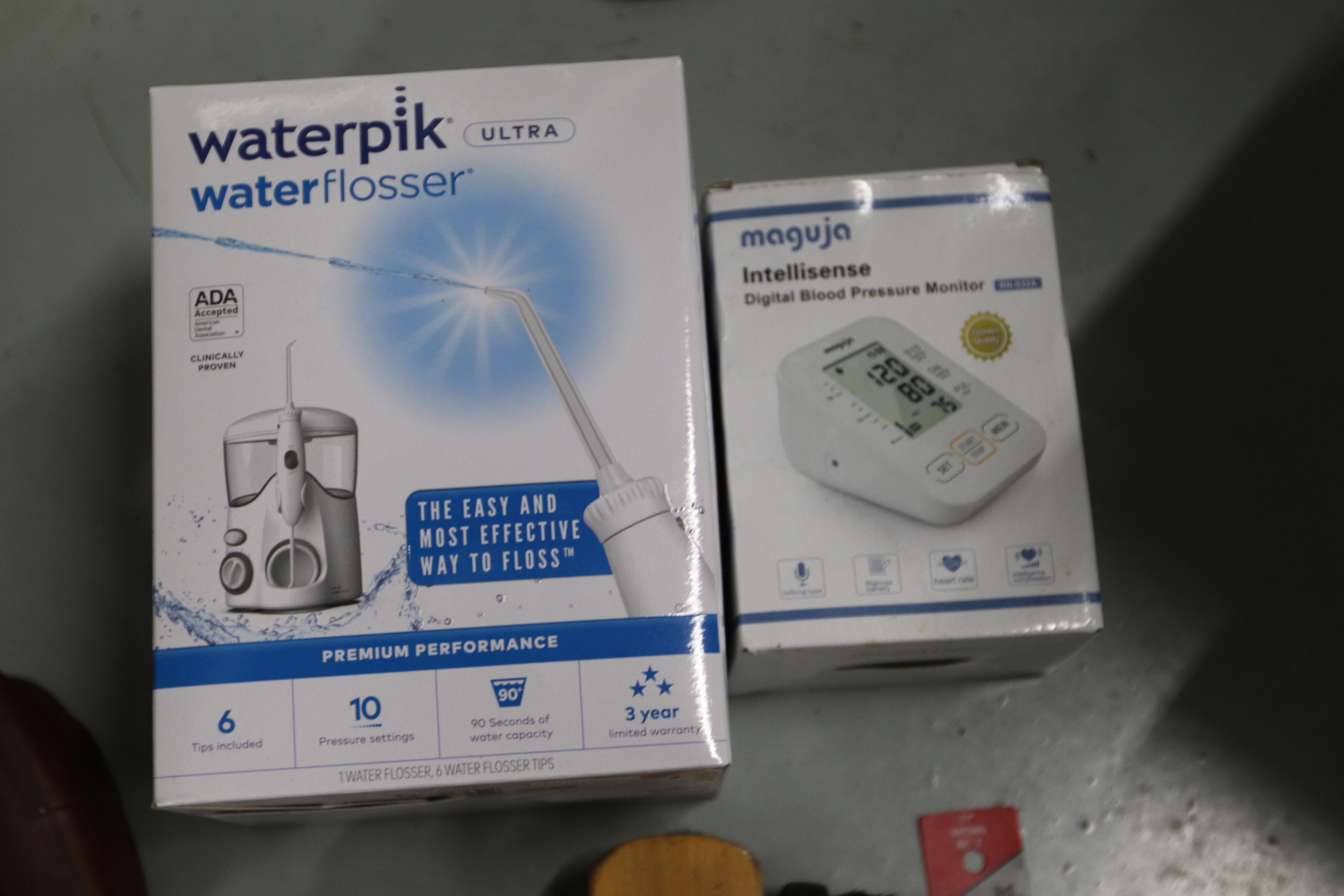 Shoe polishing brushes, scissors, vintage electric razors, and a Waterpik flosser, new in box